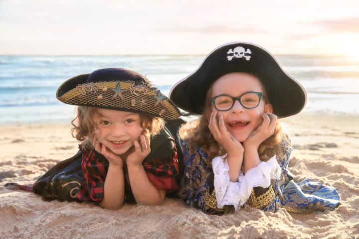 Two pirates lying side by side in the sand